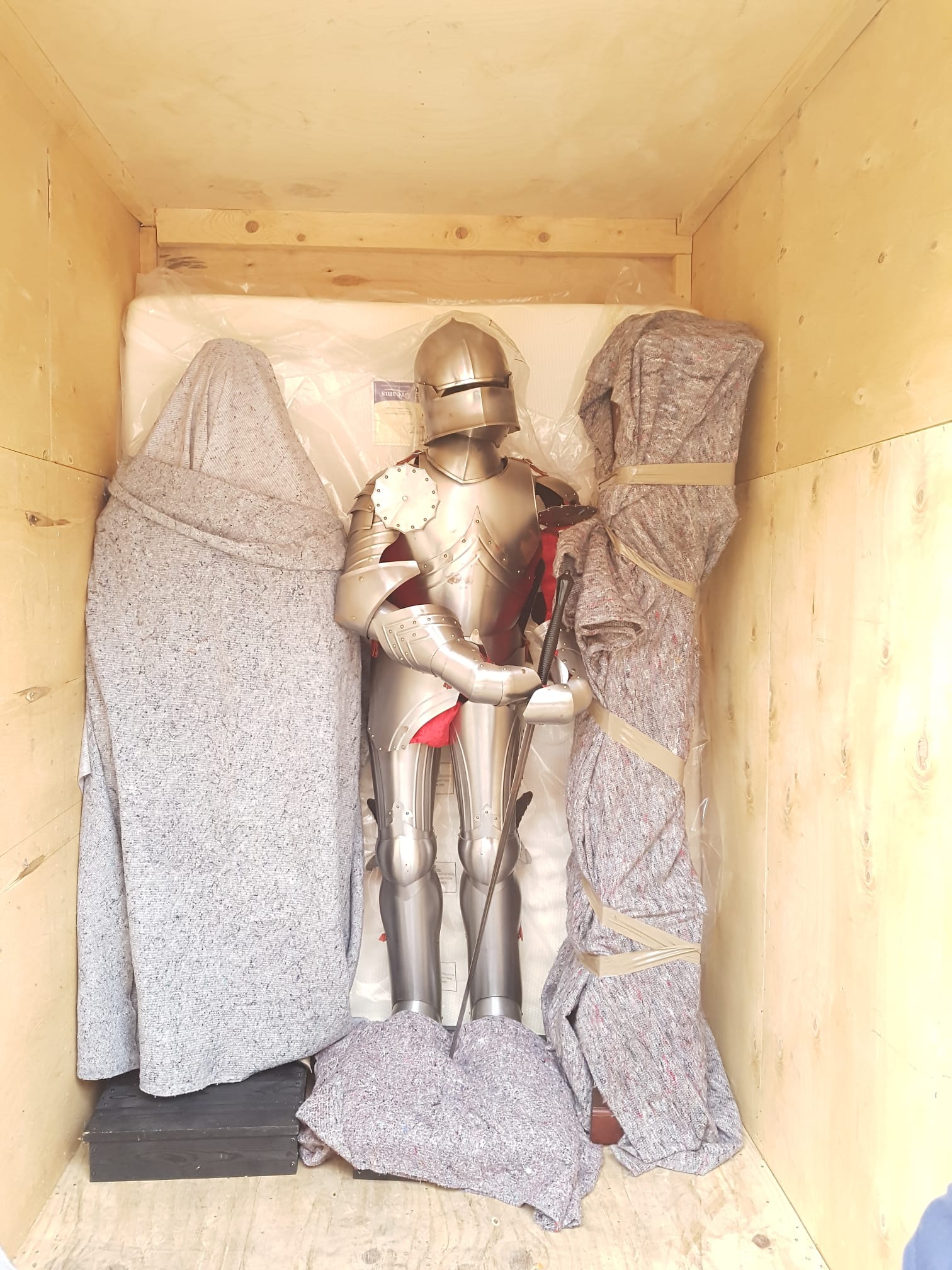 Medieval suit of armour protected inside a wooden storage crate